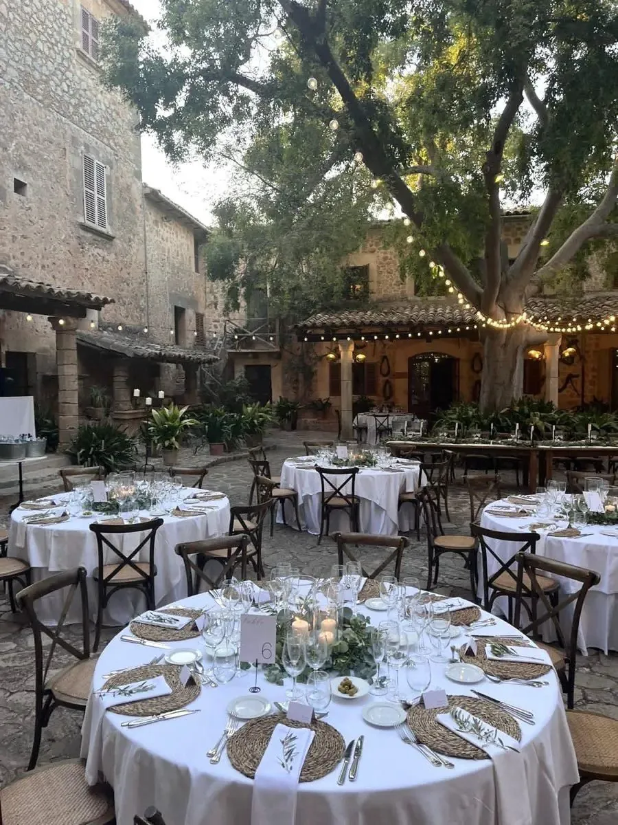 Aperitiu de boda en una masia amb taules parades i llums, sonoritzat per DJ Arik